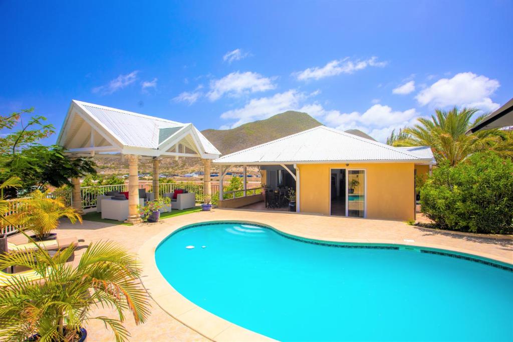 una casa con piscina frente a ella en Spacious Villa with Ocean and Mountain view-4 beds en Cul de Sac