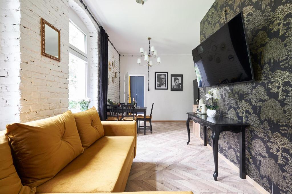 una sala de estar con un sofá y una mesa en Art Apartment Grzmiąca, en Grzmiąca