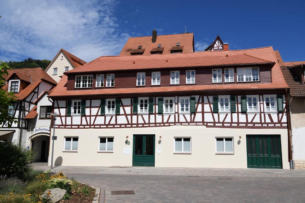 un grand bâtiment blanc avec un toit rouge dans l'établissement Das schiefe Haus- Wohnung "Nibelungen", à Heppenheim