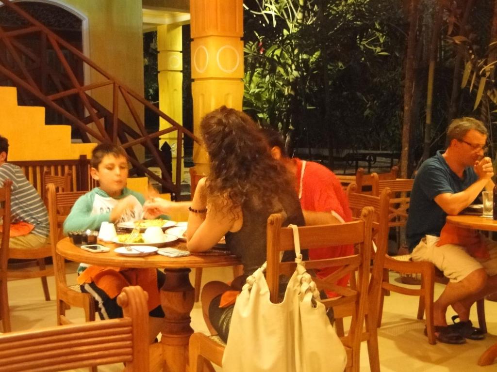 a group of people sitting at a table in a restaurant at Thambapanni Retreat in Unawatuna