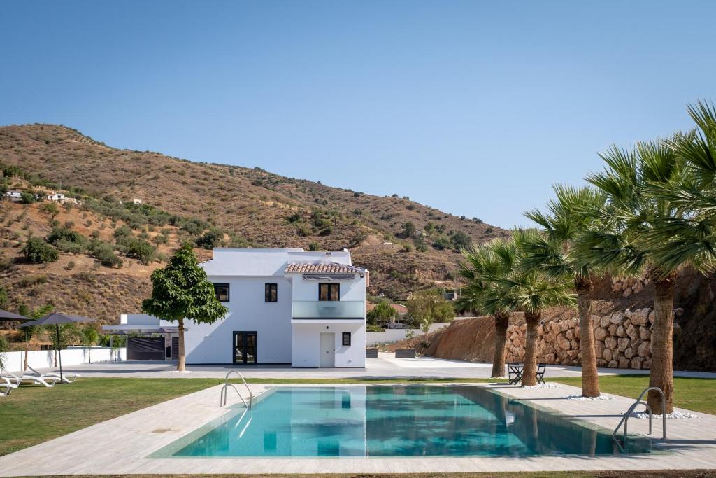 a villa with a swimming pool and palm trees at Era del Puerto 1 in Tolatán