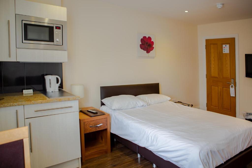 a small room with a bed and a kitchen at Marylebone Inn in London
