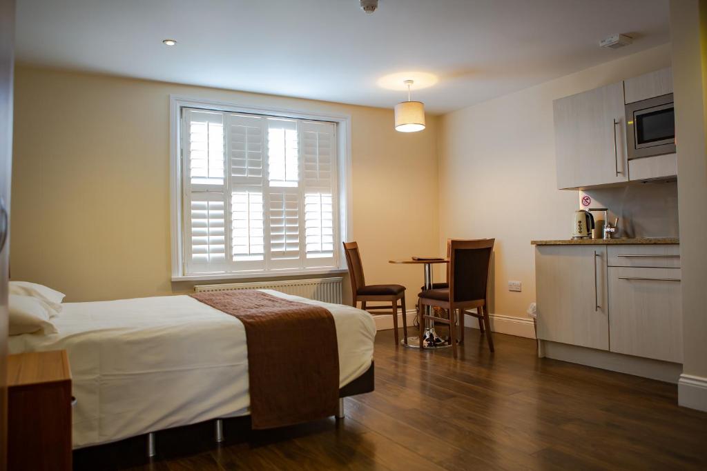 a bedroom with a bed and a kitchen with a table at Marylebone Inn in London