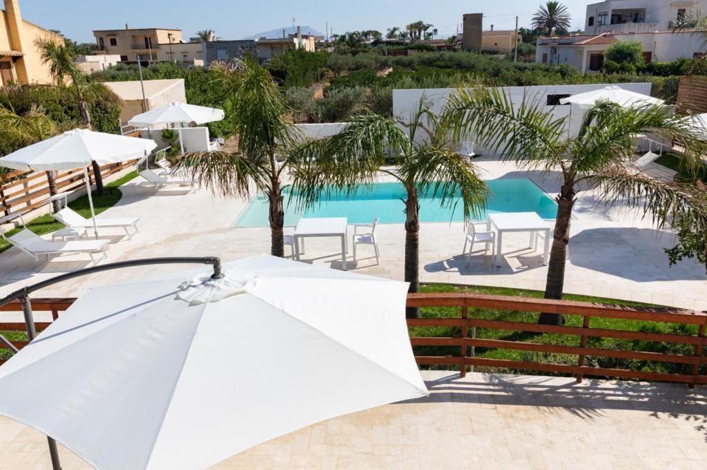 um guarda-chuva branco sentado em frente a uma piscina em Il Glicine em Marsala