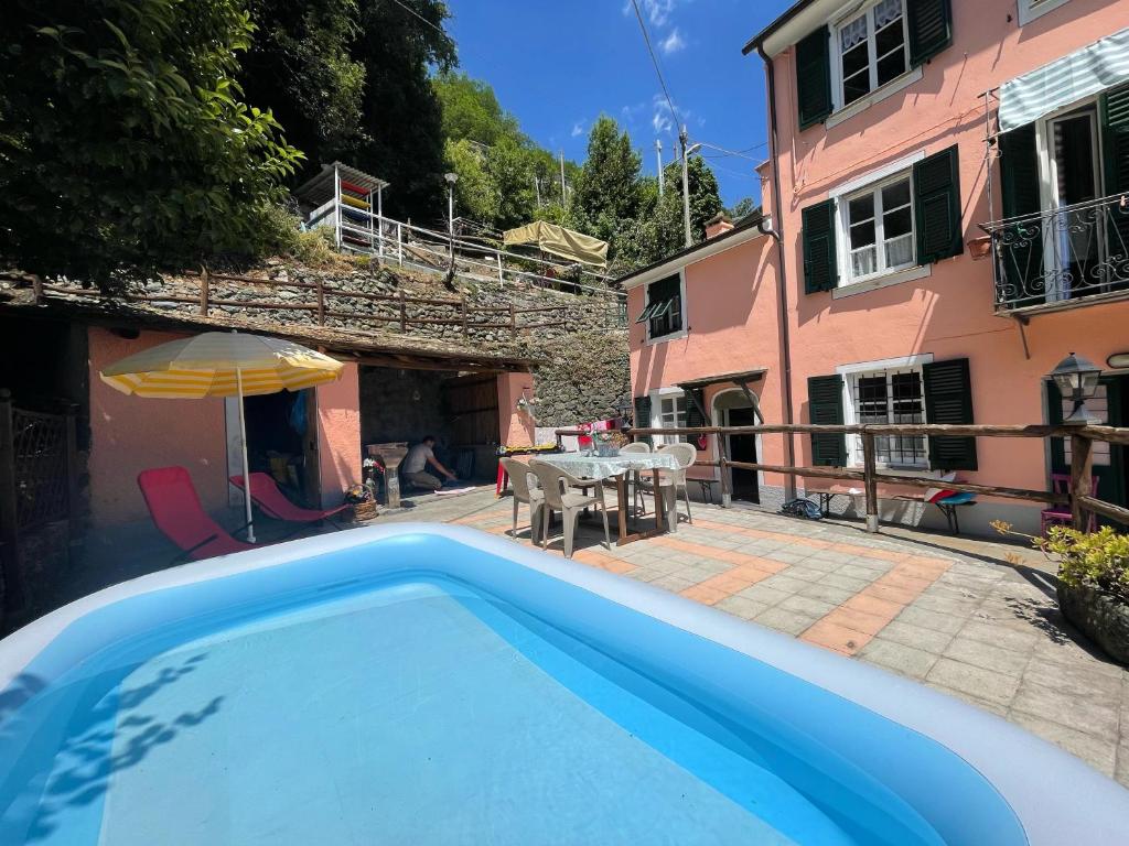 a swimming pool in front of a house at La casa con giardino, vicino al ruscello segreto in Borzonasca