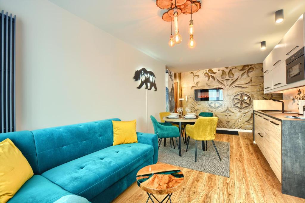 a living room with a blue couch and a table at APARTAMENT Białka Tatrzańska K1- na terenie SUN&SNOW in Białka Tatrzanska