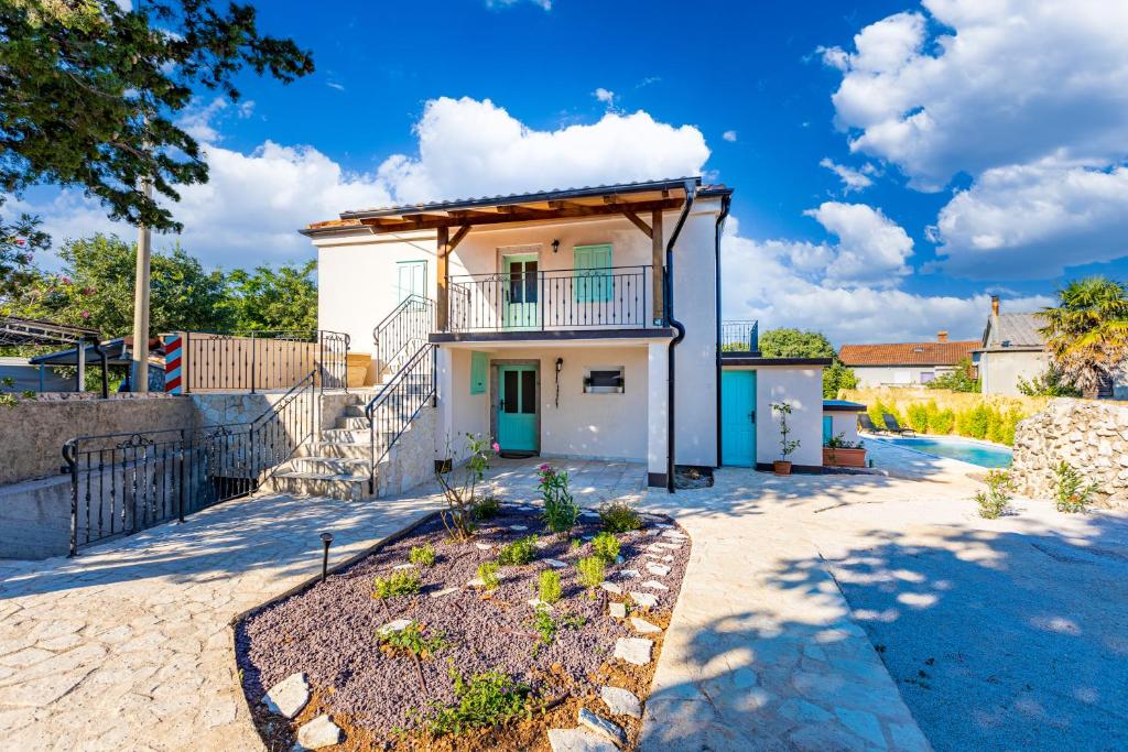 una piccola casa bianca con balcone su una strada di Paesana Heritage House a Garica