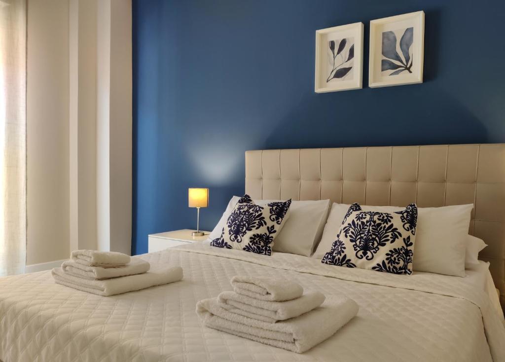 a blue bedroom with a bed with towels on it at Elpida Apartment Reggio Calabria in Reggio di Calabria