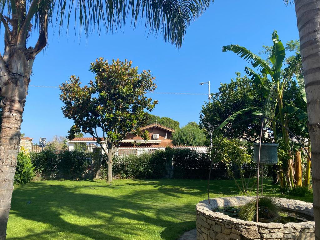 un patio con una palmera y un columpio en B&B Il Giardino Delle Meraviglie, en Melito di Porto Salvo