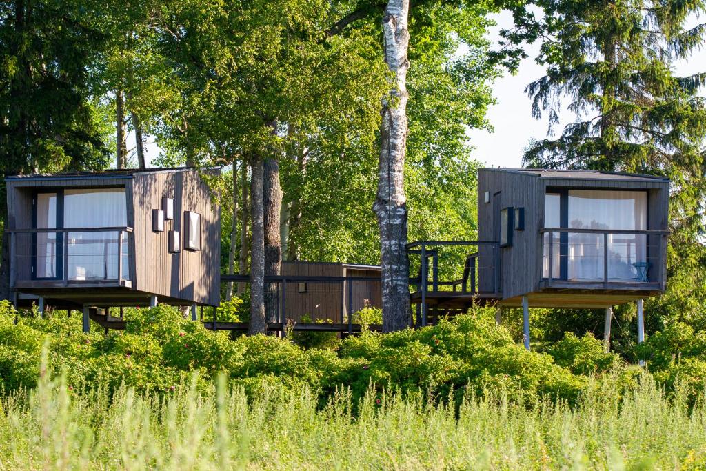 two modular houses in a forest with trees at Mornamaa puumaja Pesä 2 