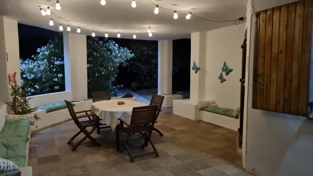 Le Farfalle Appartamento in villa trifamiliare في Porto Istana: غرفة طعام مع طاولة وكراسي وأضواء