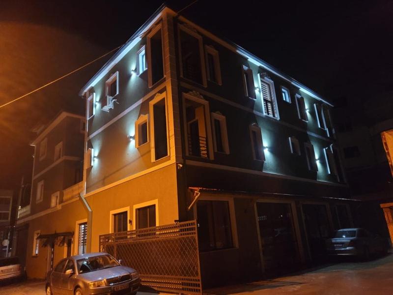 ein Auto, das nachts vor einem Gebäude parkt in der Unterkunft Vila Isi in Korçë