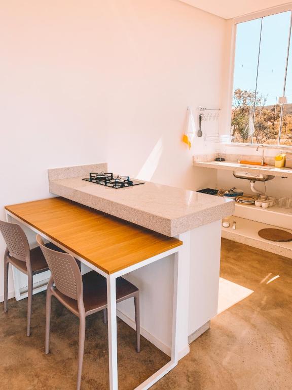 Una cocina con una mesa y sillas en una habitación. en Villa Candombá, en Alto Paraíso de Goiás