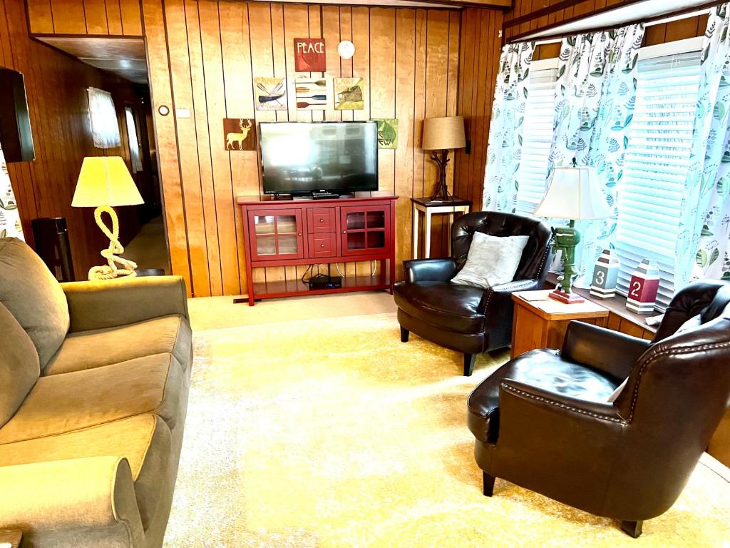 a living room with a couch and chairs and a television at White Caps Motel in Port Clinton