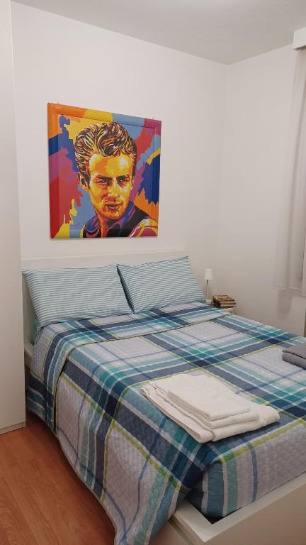 1 dormitorio con 1 cama con una pintura en la pared en Al teatro, en Padua