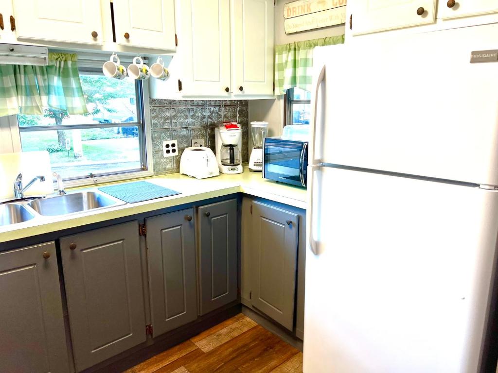 a kitchen with a white refrigerator and a sink at White Caps Motel in Port Clinton