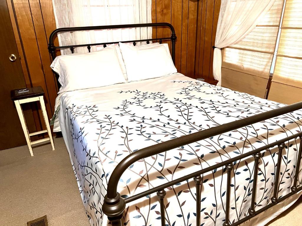 a bedroom with a bed with a black and white comforter at White Caps Motel in Port Clinton
