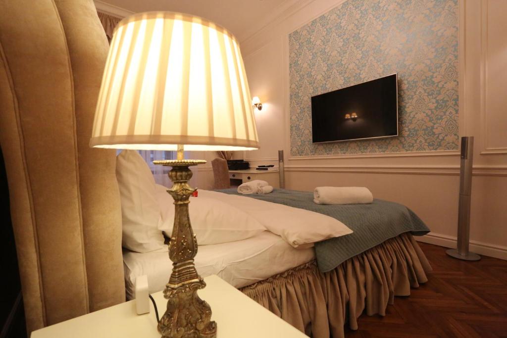 a bedroom with a bed with a lamp and a television at Blueberry Apartments in Krakow