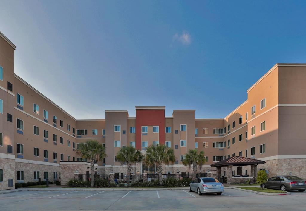 a large building with cars parked in a parking lot at Free Parking Free Wifi with Kitchen Washer Dryer Relux Studio Group 1 in Houston