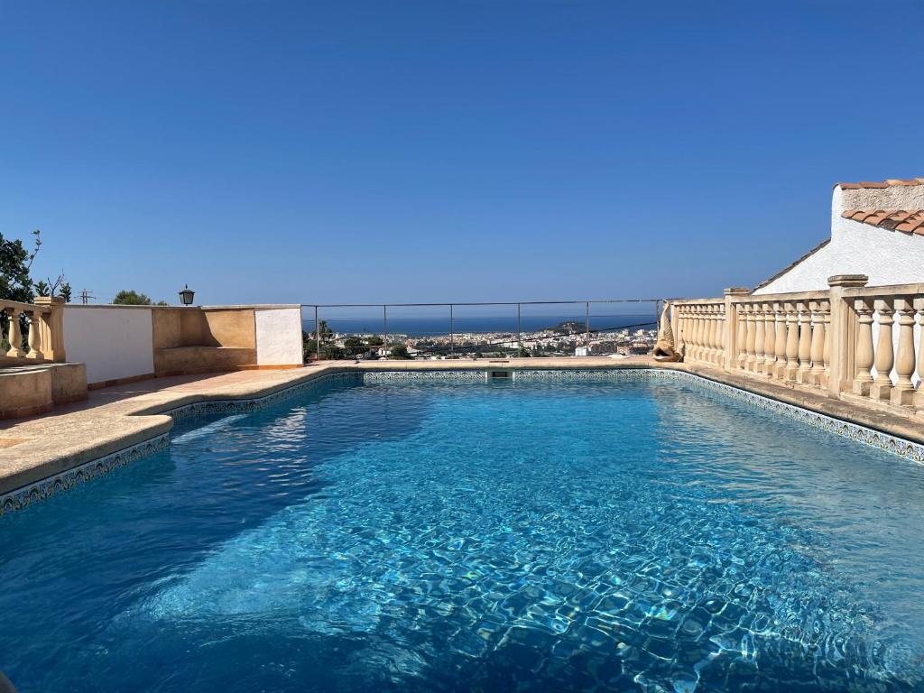 uma piscina com água azul e uma varanda em Castell De Mar em Denia