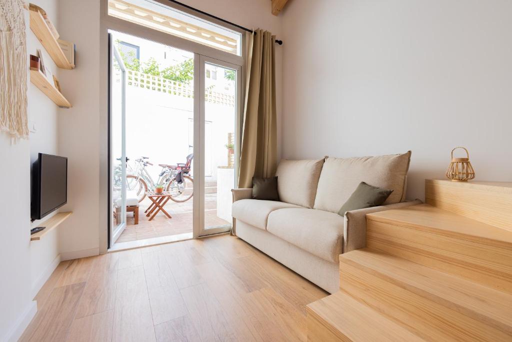 Hotel Casa Valenciana con Terraza, a living room with a couch and a sliding glass door at Casa Valenciana con Terraza in Valencia