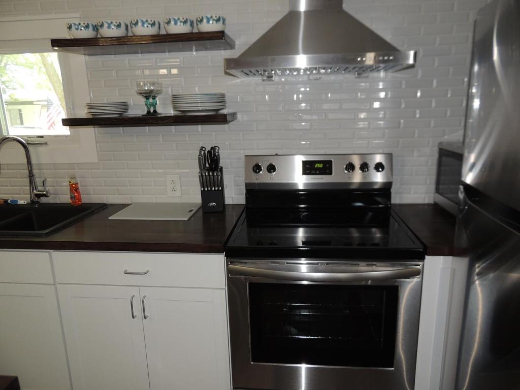 a kitchen with a stove and a sink at White Caps Motel in Port Clinton