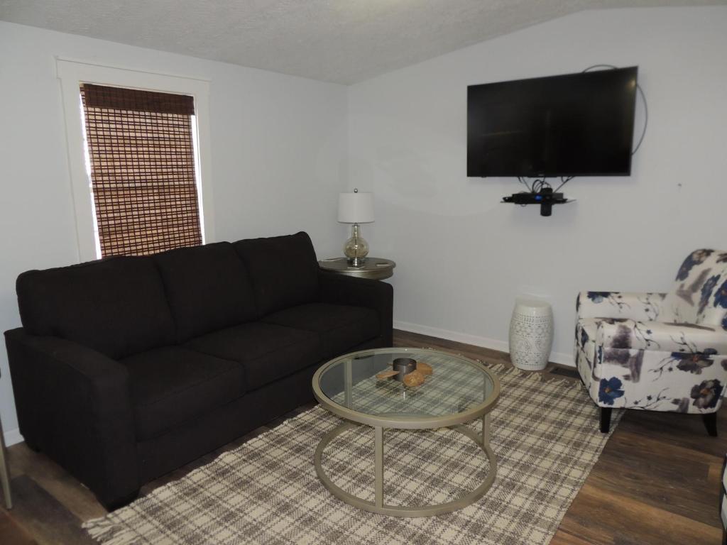 a living room with a black couch and a table at White Caps Motel in Port Clinton