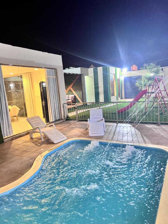 a large swimming pool with two chairs and a slide at Sydra Chalet in Riyadh