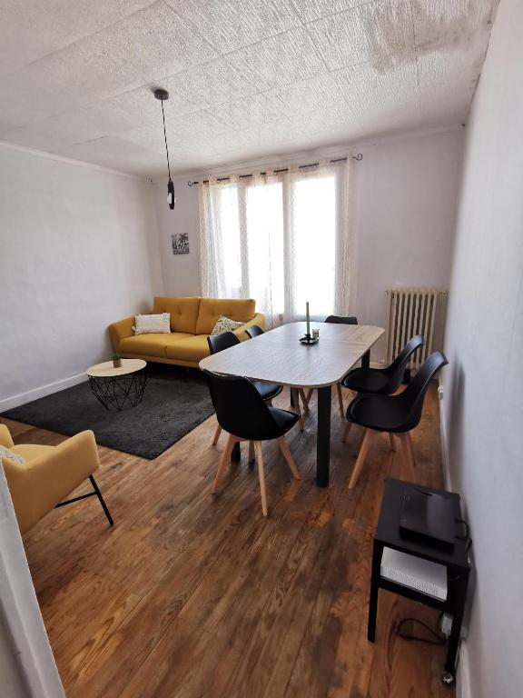 a living room with a table and chairs and a couch at Appartement lumineux vue Pic du Midi in Lannemezan