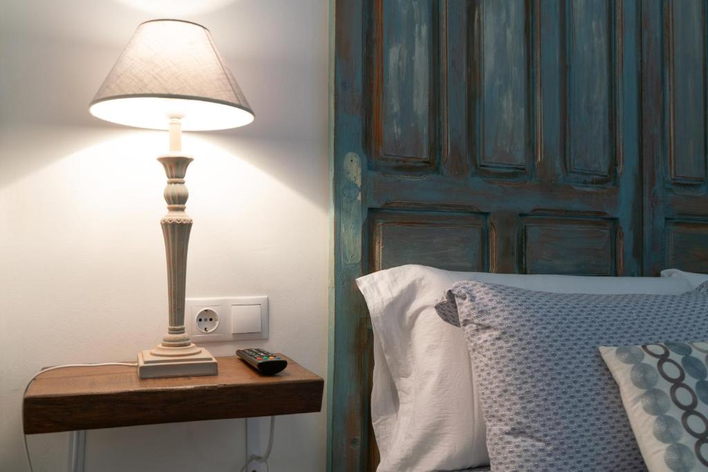 una lámpara en una mesita de noche junto a una cama en Apartamento Santa Leocadia, en Toledo
