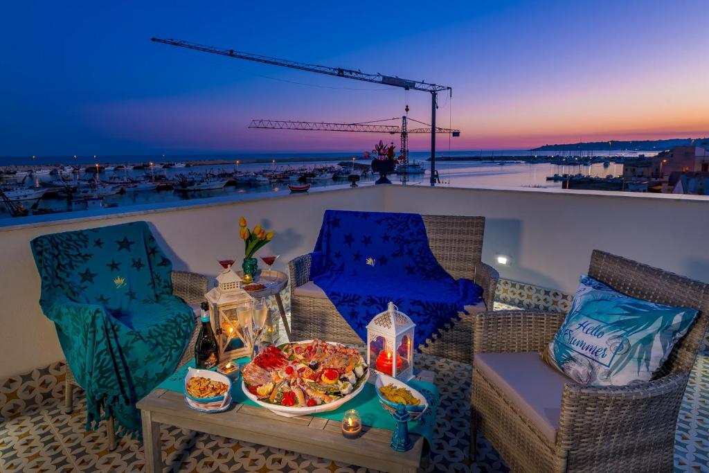 a table with a bowl of food on a balcony at Vittoria Luxury Rooms in Sciacca