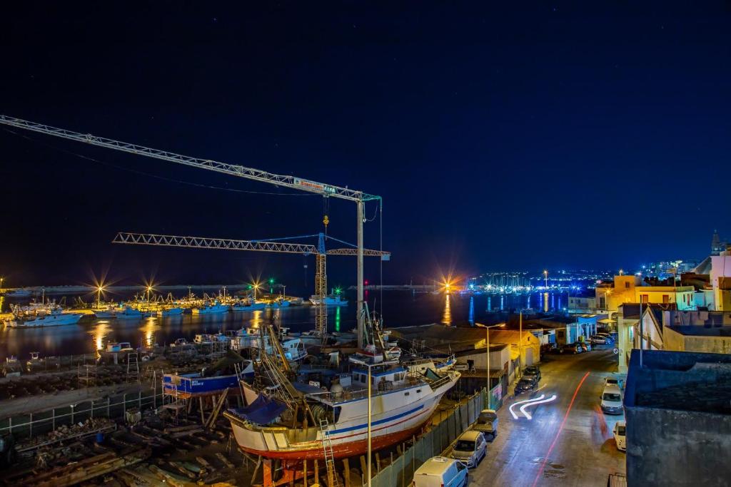 a boat docked in a harbor at night at Vittoria Luxury Rooms in Sciacca