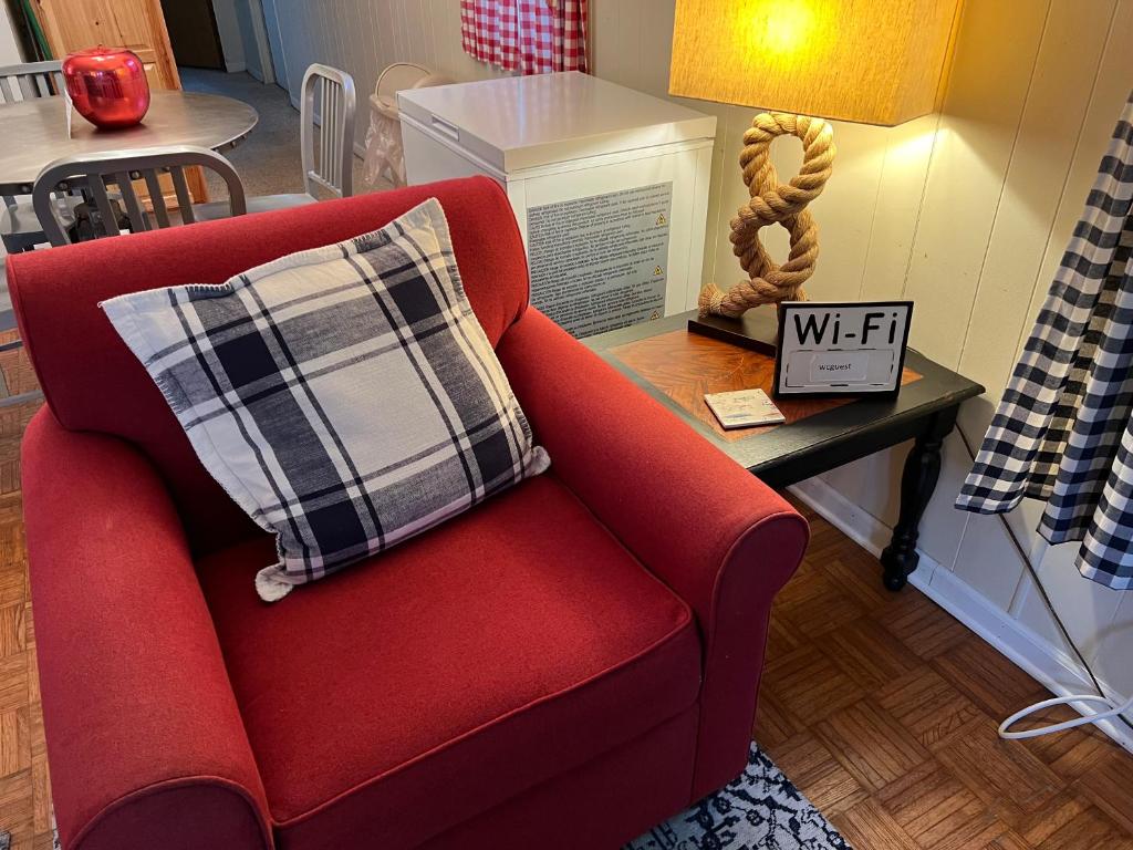 a red couch with a plaid pillow on a table at White Caps Motel in Port Clinton