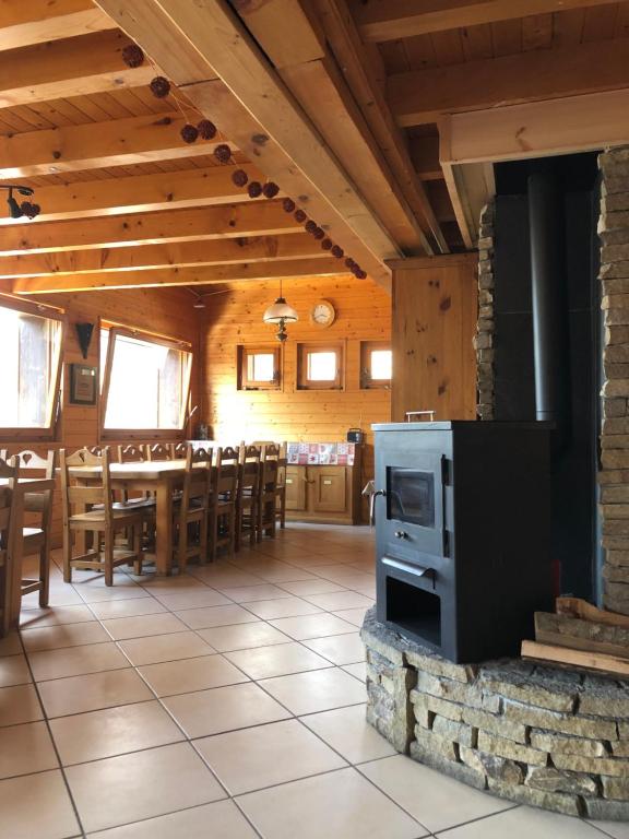 a room with a kitchen and a dining room with a stove at Central Hostel Chatel in Châtel