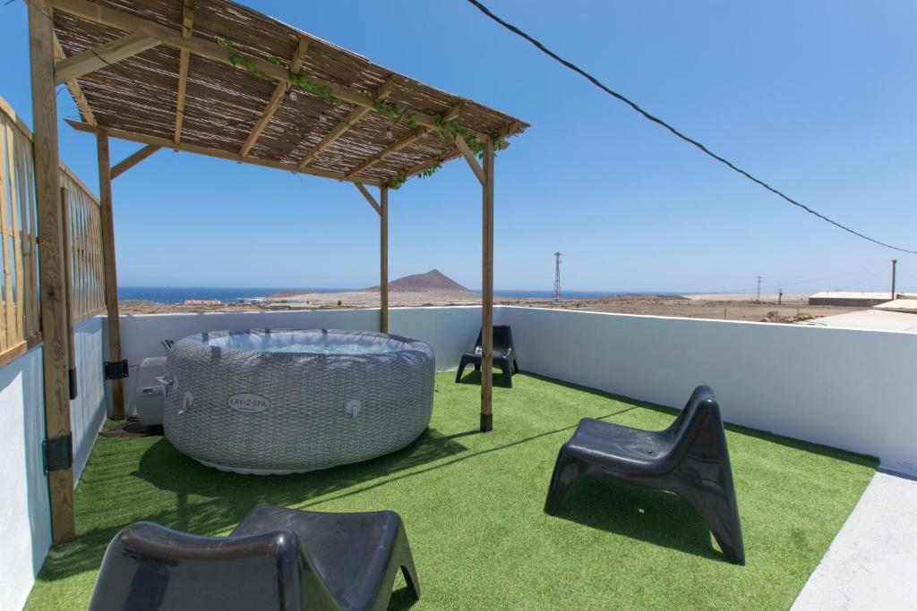 un patio con sillas y una mesa en el techo en La casita de Aitor; campo y playa en el Médano, en El Médano