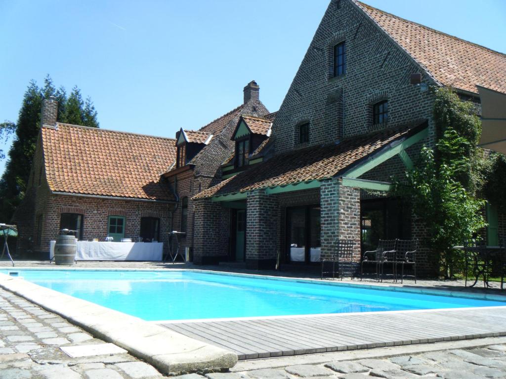 a swimming pool in front of a house at Gîte Du Haut Ballot in Wambrechies