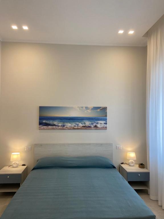 een slaapkamer met een groot bed met 2 nachtkastjes bij Perla Marina Luxury apartments in Margherita di Savoia