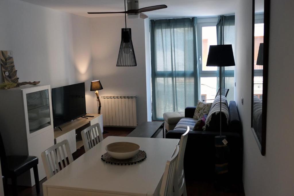 - un salon avec un canapé, une télévision et une table dans l'établissement Apartament Ramon a Pobla, à Pobla de Segur