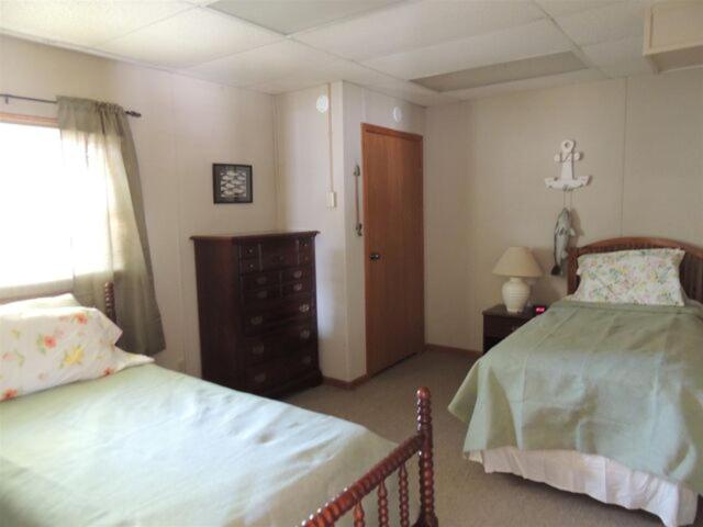 a bedroom with two beds and a dresser and a window at White Caps Motel in Port Clinton