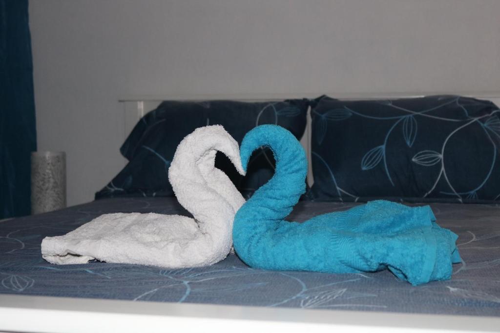 dos cisnes de toalla sentados en la parte superior de una cama en Le Moringa, en Baie-Mahault