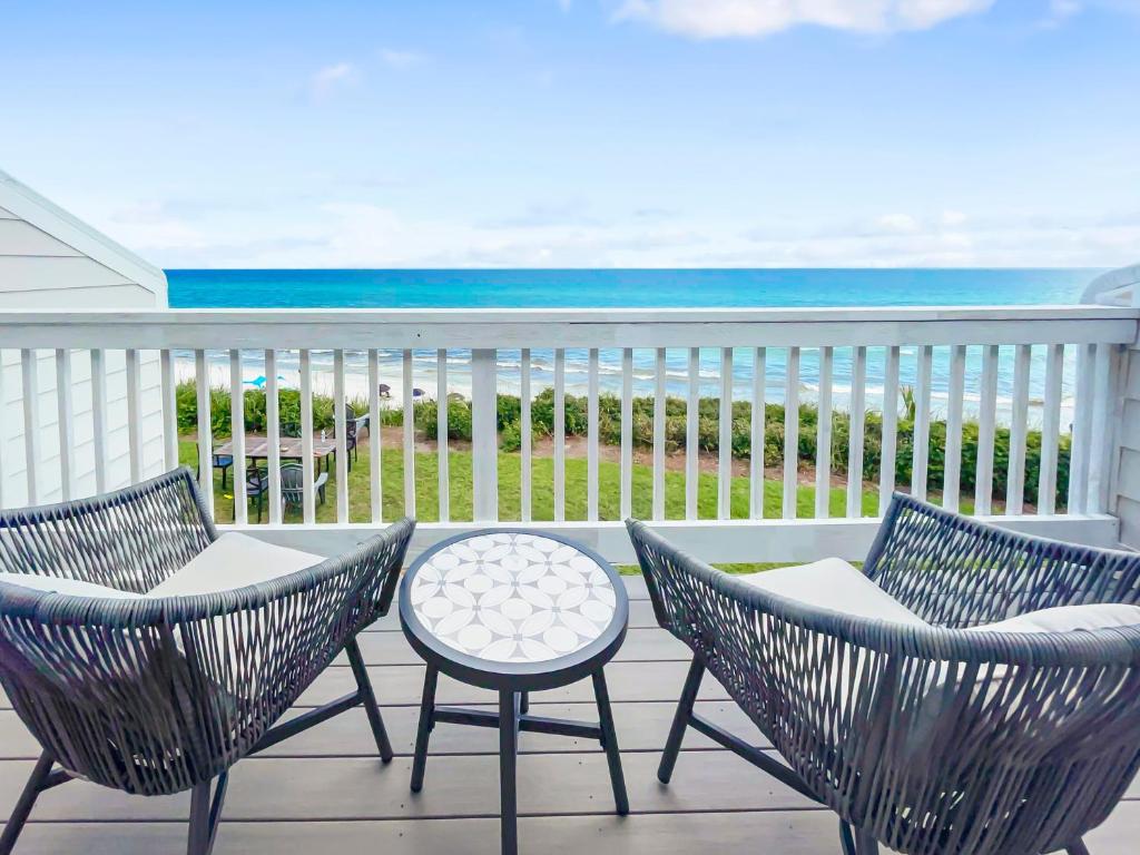 a balcony with chairs and a table and the ocean at Seacrest - 6 Townhouse in Watersound Beach