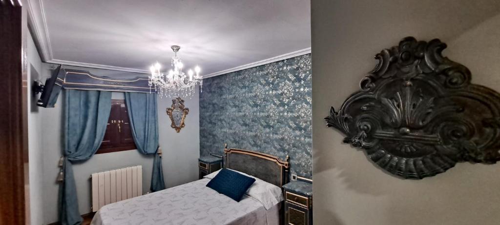 1 dormitorio con cama y lámpara de araña en Vivienda de uso turístico Domus Josefae, en Salamanca