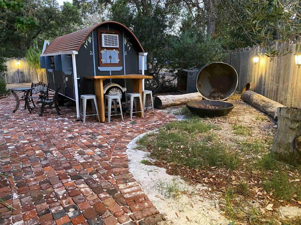 a play house with a table and a grill at Gypsy Van Tiny House with Unique Outdoor Bathroom, WIFI & Firepit in Coodanup