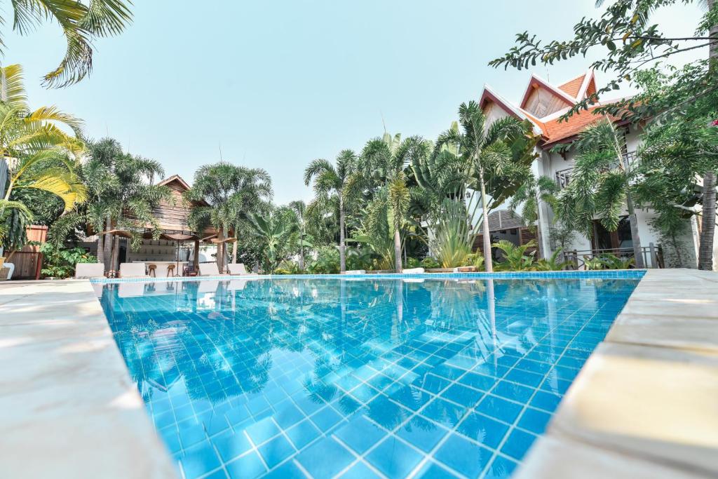 a swimming pool in front of a villa at Oh Battambang Boutique Hotel in Battambang