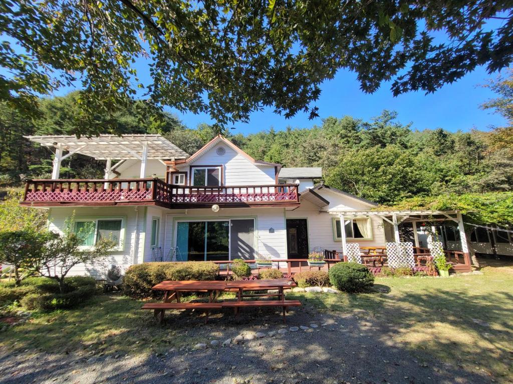 a house with a picnic table in front of it at White House Over Hill in Yangyang