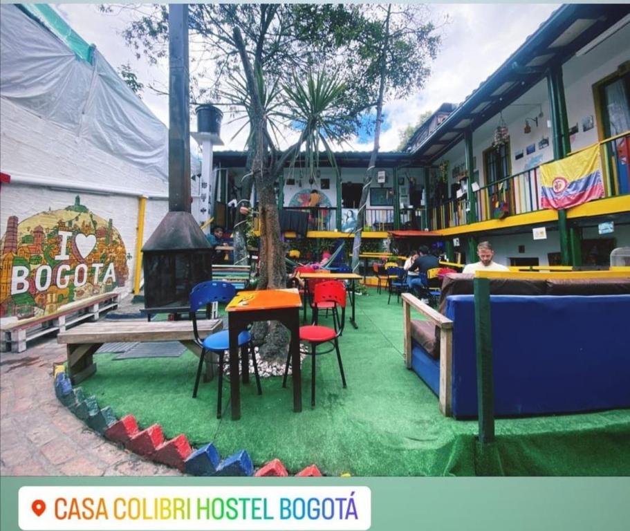 波哥大的住宿－Hostal Gastro Bar Casa Colibrí，一间草地上配有桌椅的餐厅
