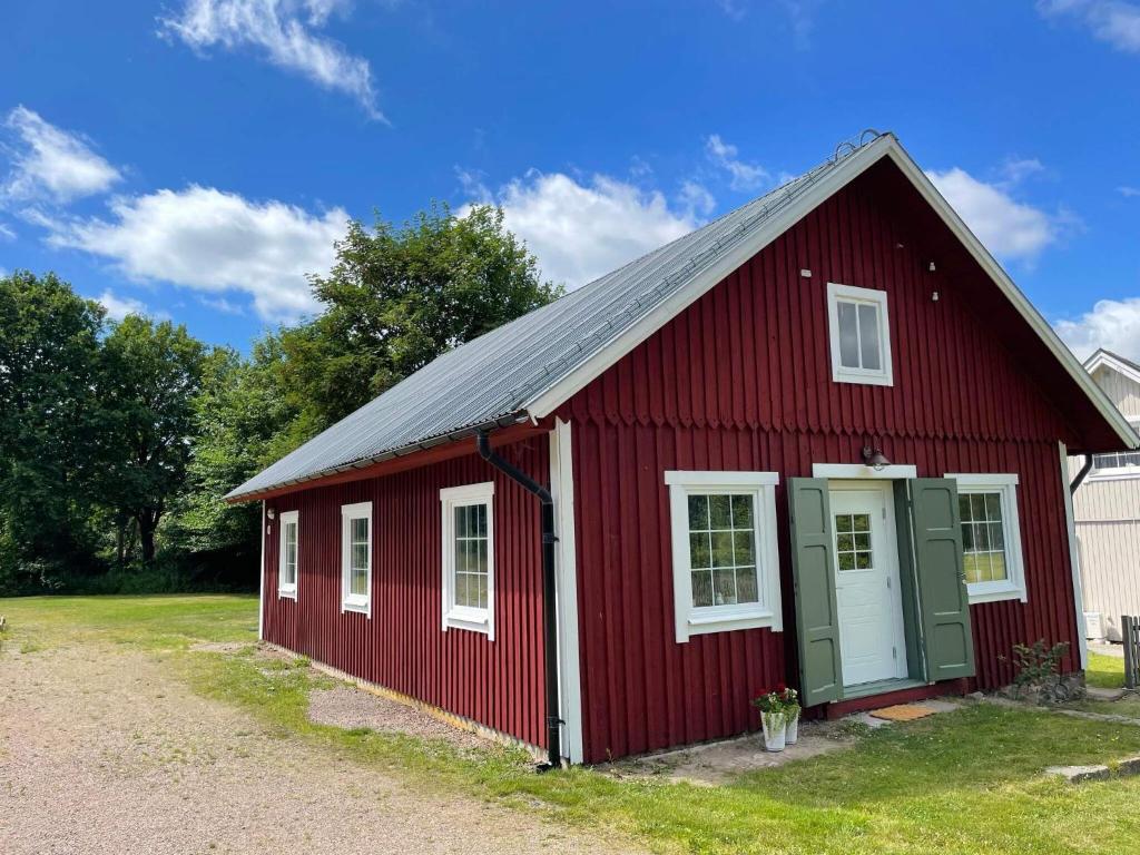 Ljungbyhed的住宿－Holiday home Ljungbyhed II，红色谷仓,有白色的门和窗户