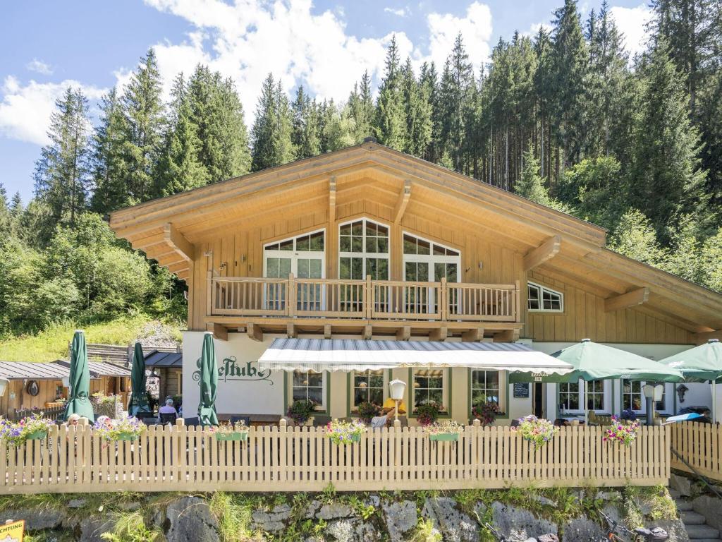 a large log cabin with a porch and a restaurant at Pretty Holiday Home in Hollersbach im Pinzgau with Garden in Hollersbach im Pinzgau