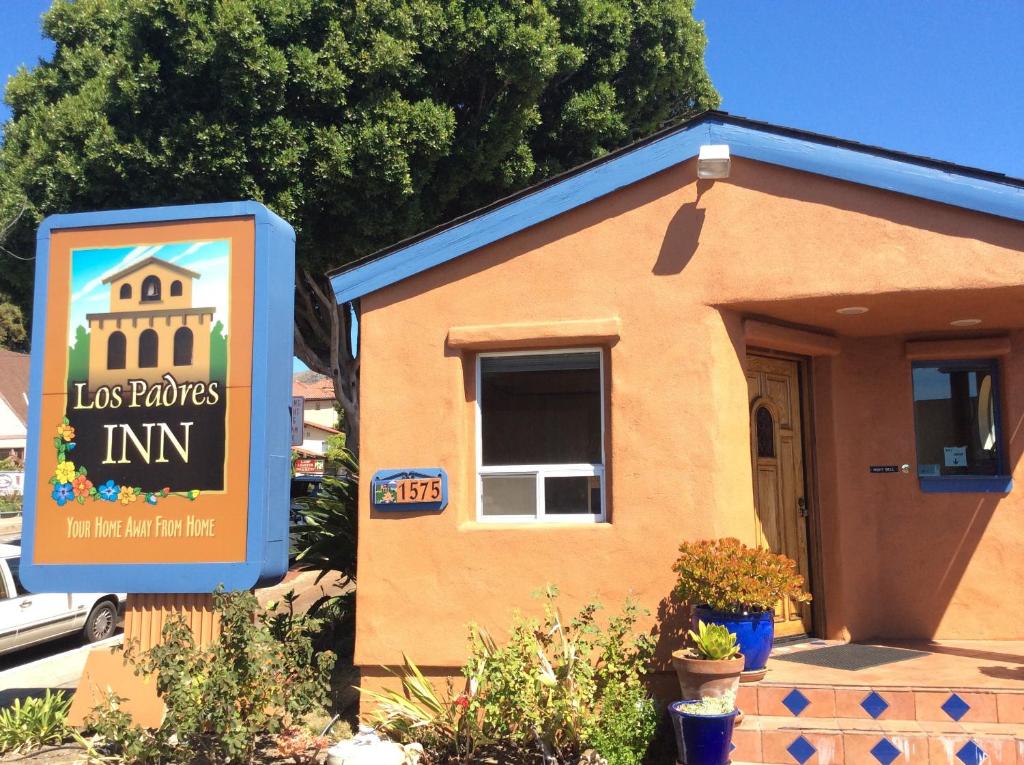 una pequeña casa con un cartel delante en Los Padres Inn, en San Luis Obispo