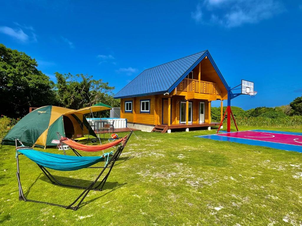 a house with a tent and two hammocks and a basketball hoop at レジーナ石垣ログテリアⅡ in Hirakubo